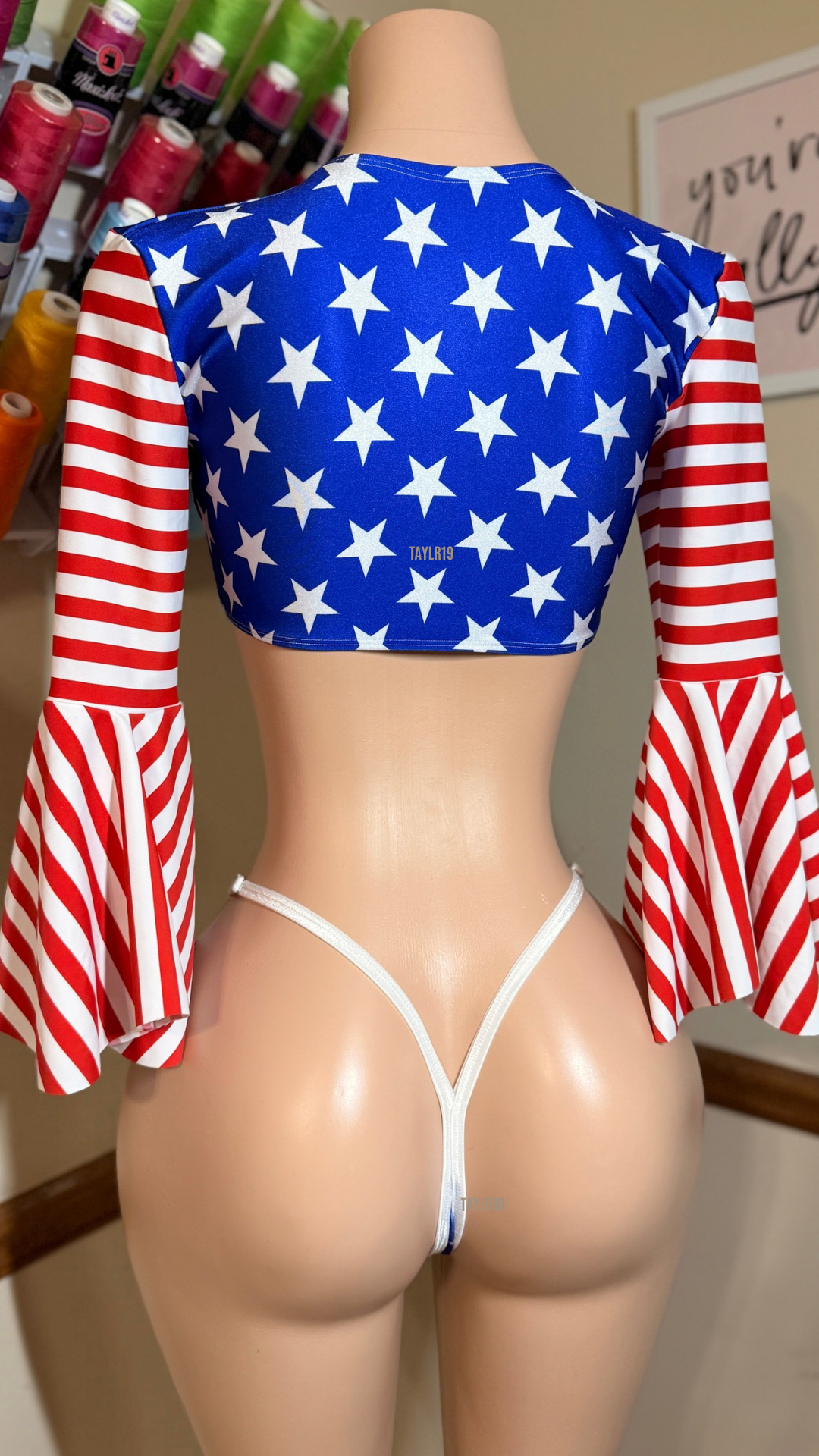 Women’s patriotic slingshot set featuring a tie-front crop top with dramatic bell sleeves and an adjustable slingshot bottom. Handmade exotic dancewear for entertainers, festivals, and themed events by Taylr19.
